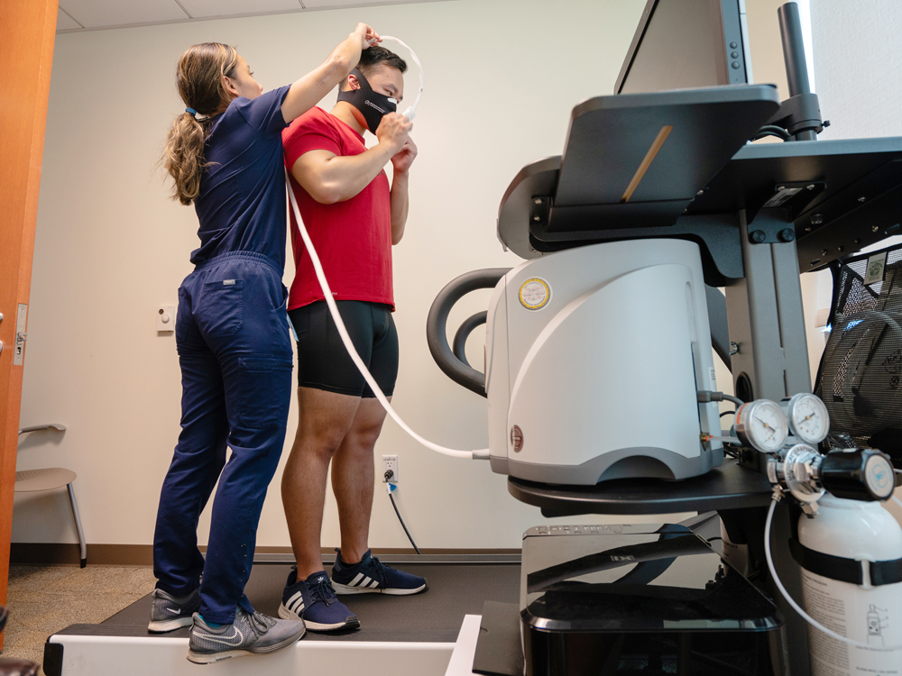 Study participant getting ready for the treadmill with help from study coordinator